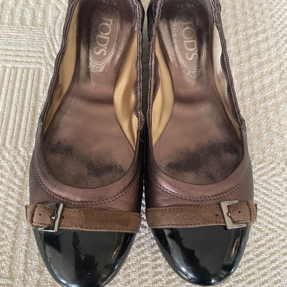 Tod’s bronze and black patent leather ballet flats.
